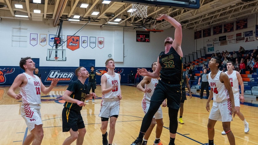 Payton Dean going up for a layup with players looking on.