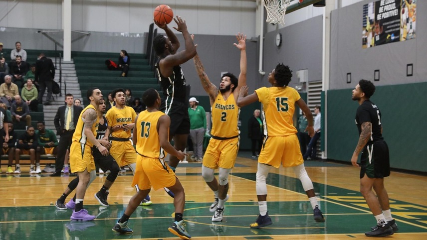 The Broncos defending an opposing player shooting a shot in the paint.