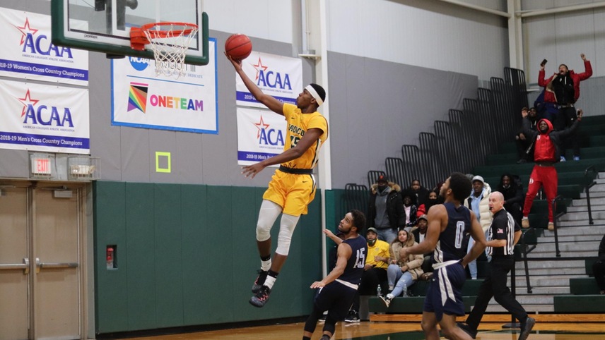 Basketball player driving towards hoop for layup.