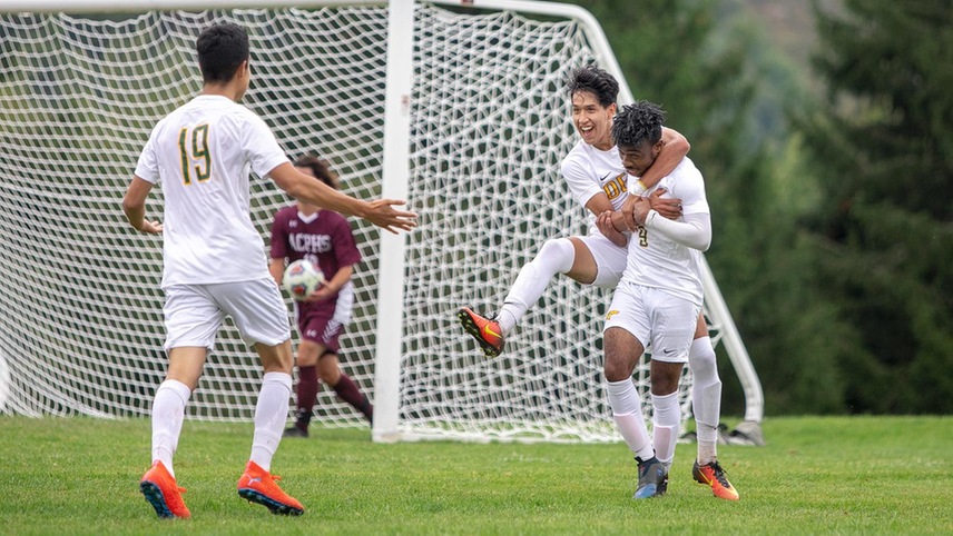 Juan Velez with his arms around Denzel Monexant, celebrating after a goal.