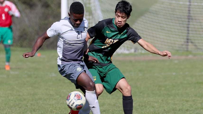 Emmanuel Gonzales fighting for possession of the ball against an opponent.