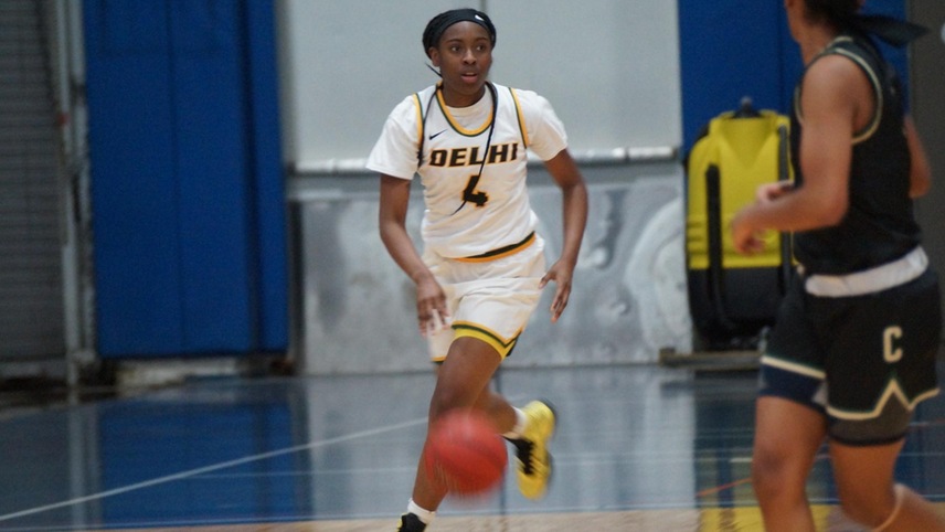 Camryn McDonald #4 dribbling the ball up court looking downcourt.