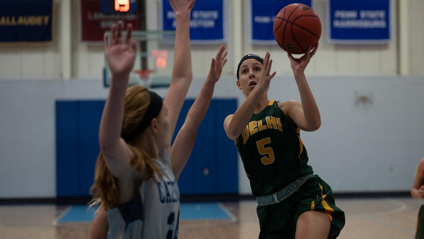 Justine Lubbers #5 going up for a layup with a defender in front of her.