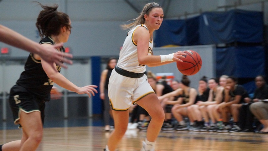 Sam Acuna bringing the ball down the court past a defender.
