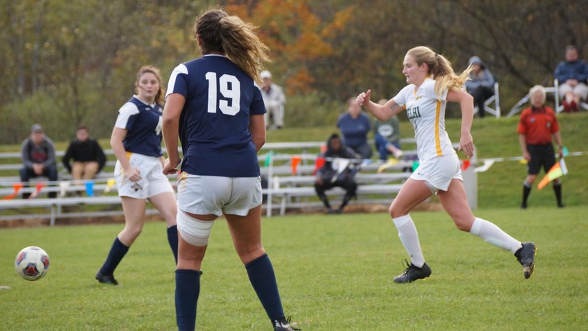 Alexa DuBois running after a ball between two opposing players. 