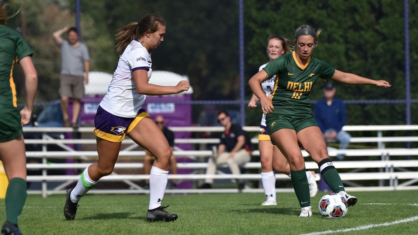 Sam Acuna gathering the ball with a defender closing in.