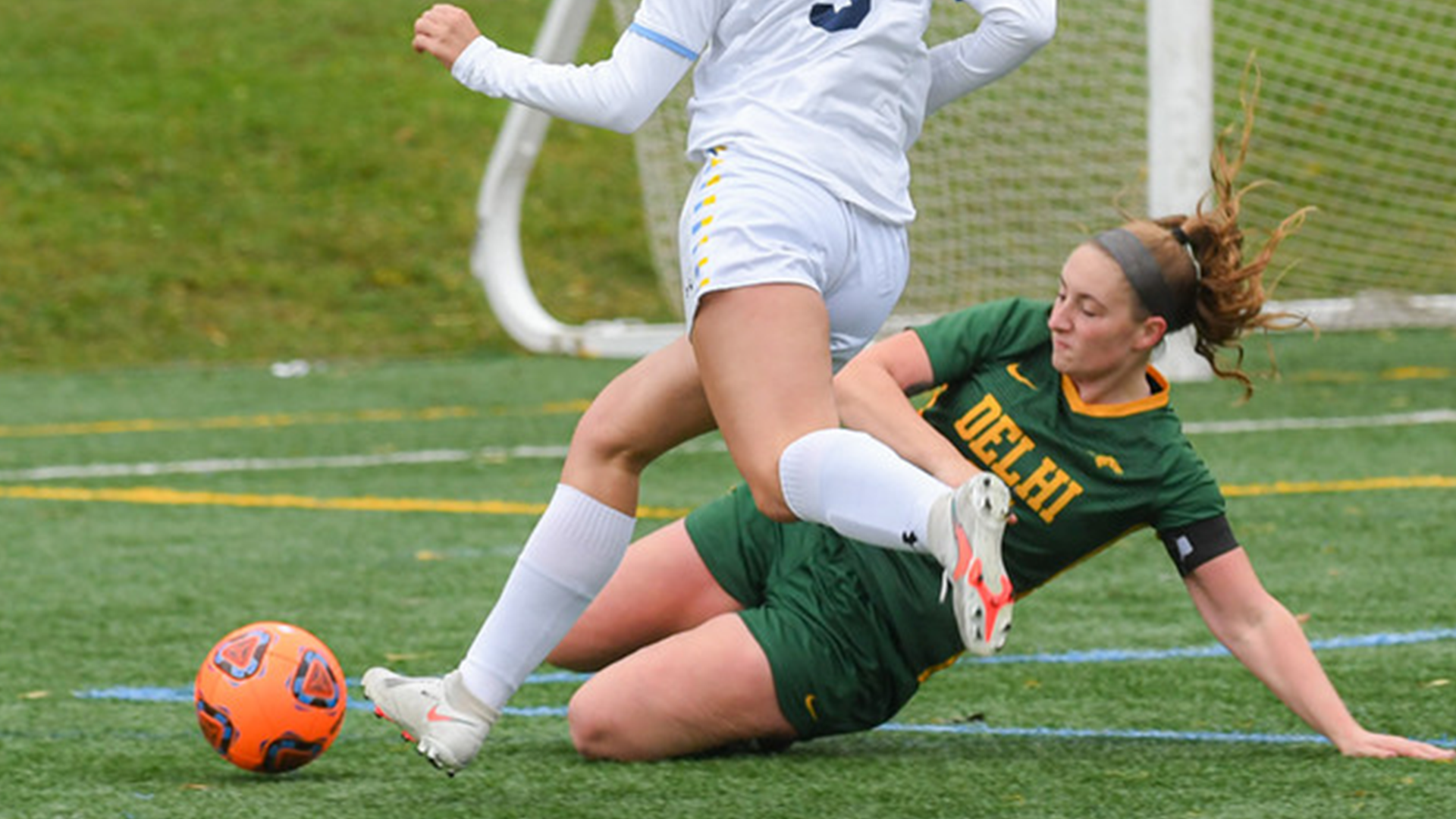 soccer defender making a sliding tackle